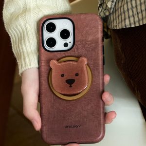 The case held against a cream knitted sweater, bear holder standing proud