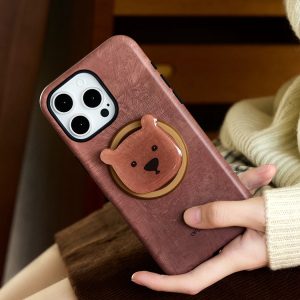 The brown case held beside dark wooden stairs, bear head catching the light