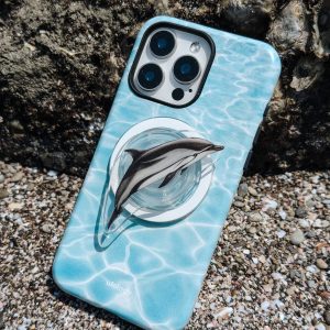 Turquoise dolphin case lying on pebbles with the magnetic holder in place