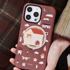 Brown little house case held against a plaid coat, cottage holder in place