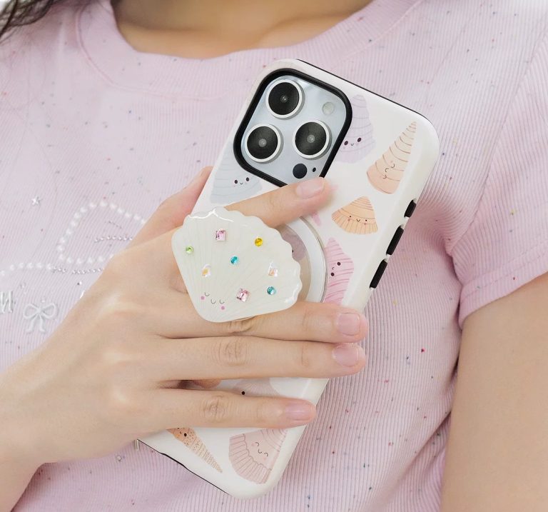Hands gripping the case by its shell holder, pink t-shirt behind