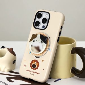 Lion case propped against a mug next to a small calico cat figurine