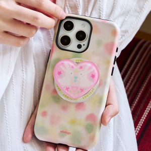 Pastel watercolor case held against a white cotton dress
