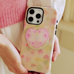 Soft pink and green case held in both hands beside a pink knit