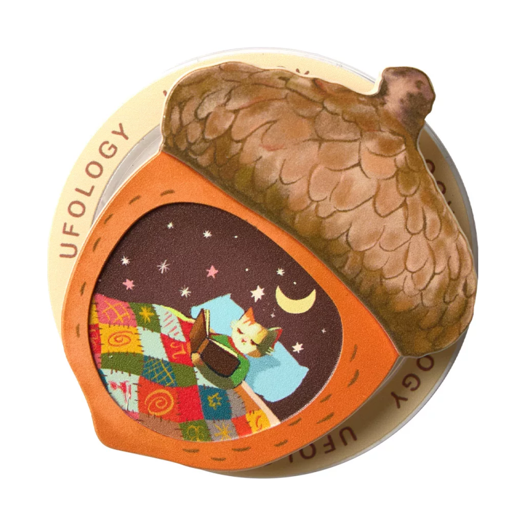 Acorn MagSafe phone grip, a brown acorn with a window showing a cat asleep under a quilt