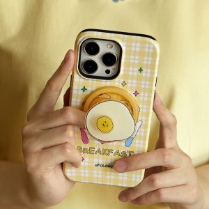 Two hands holding the yellow breakfast case with its smiling egg holder