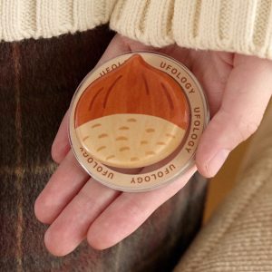 Open hand holding the chestnut grip over a plaid blanket
