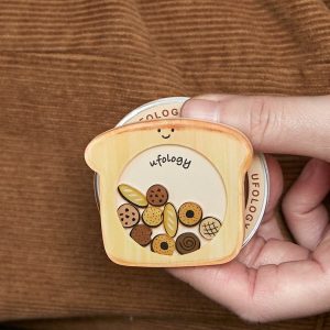 Hand holding the cookie toast grip against a brown corduroy sleeve