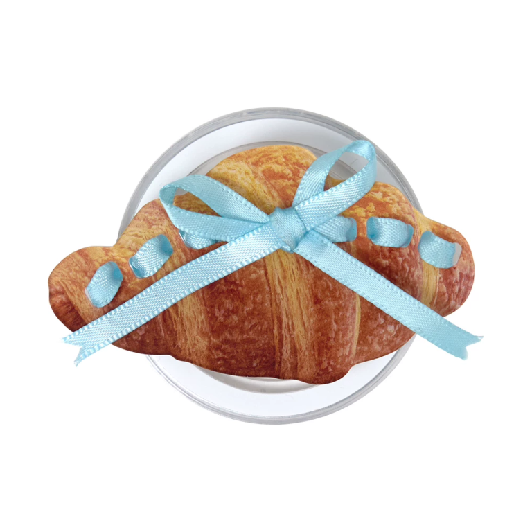 Croissant bow MagSafe phone grip, a golden croissant tied with a sky-blue ribbon