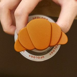 Hand holding the croissant grip, showing its layered shape from above