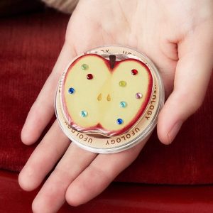 Open hand holding the jewel apple grip against a red background