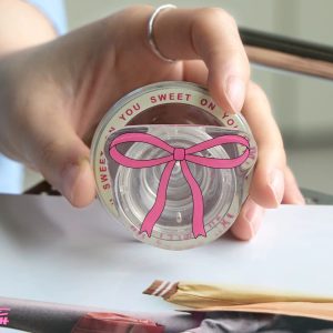 Hand holding the clear pink bow grip