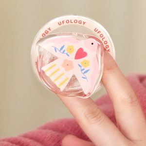 Hand holding the pink dove grip against a pink sweater