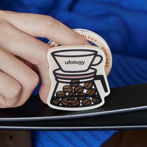 Hand holding the pour-over coffee grip against a blue sleeve