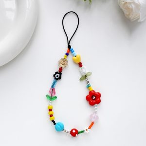 Red flower phone charm, a beaded wrist strap with a red flower and colorful beads on a black cord – styled shot