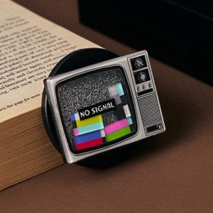 Retro TV grip standing on an open book on a brown table