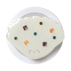 Seashell MagSafe phone grip, a white scallop shell with small colored stones on a clear base