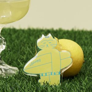 Surf cat grip standing on green grass beside a lemon