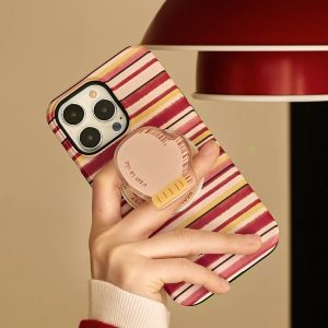 Hand holding the red striped case with its mitten holder under a red lamp